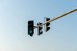 A green traffic light captures the start of a journey under a clear blue sky.